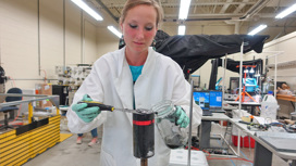 Геомикробиолог Джудит Клатт соскребает микробный мат с верхней части осадочного керна, собранного в озере Гурон.