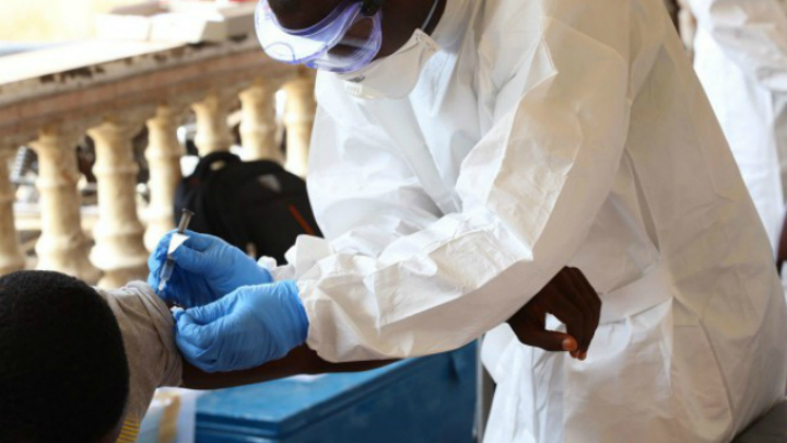 Житель гвинейской столицы Конакри получает экспериментальную вакцину в апреле 2015 года 